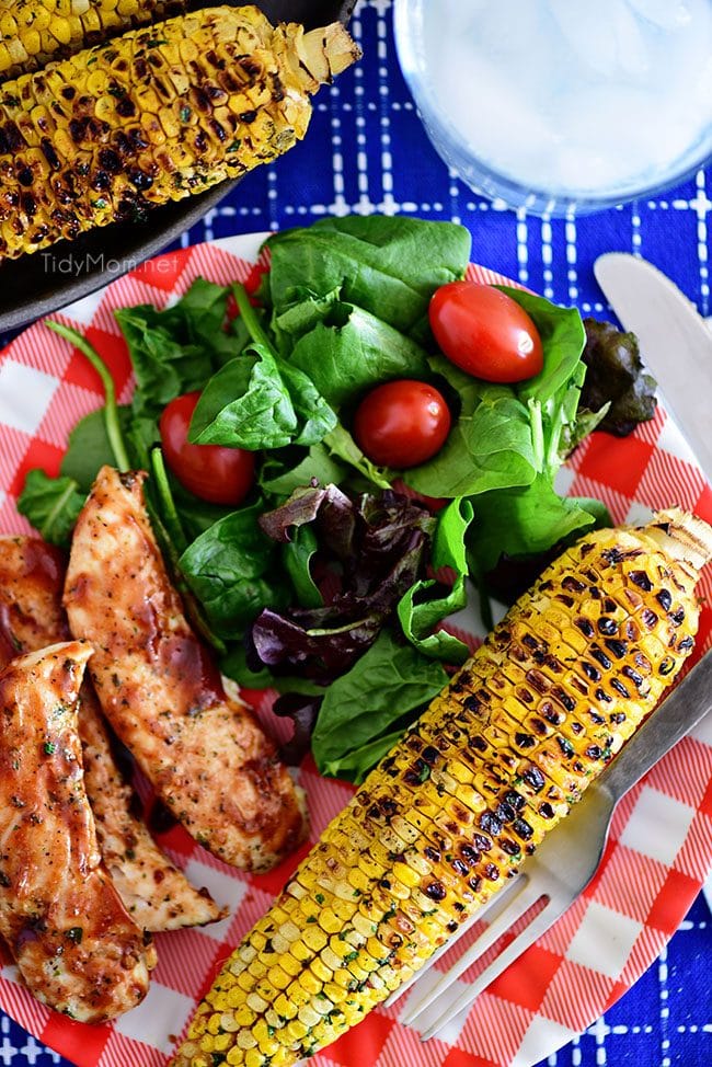 Chili Lime Corn On The Cob on dinner plate with BBQ chicken and salad