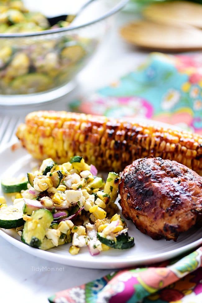 delicious grilled corn and zucchini salad on a plate with corn on the cob and chicken
