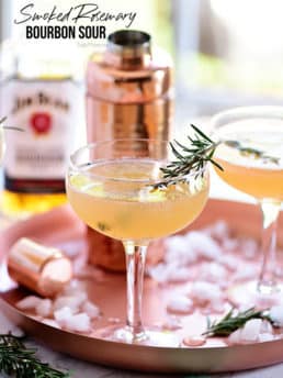 Bourbon Sour with smoked rosemary in coupe glasses