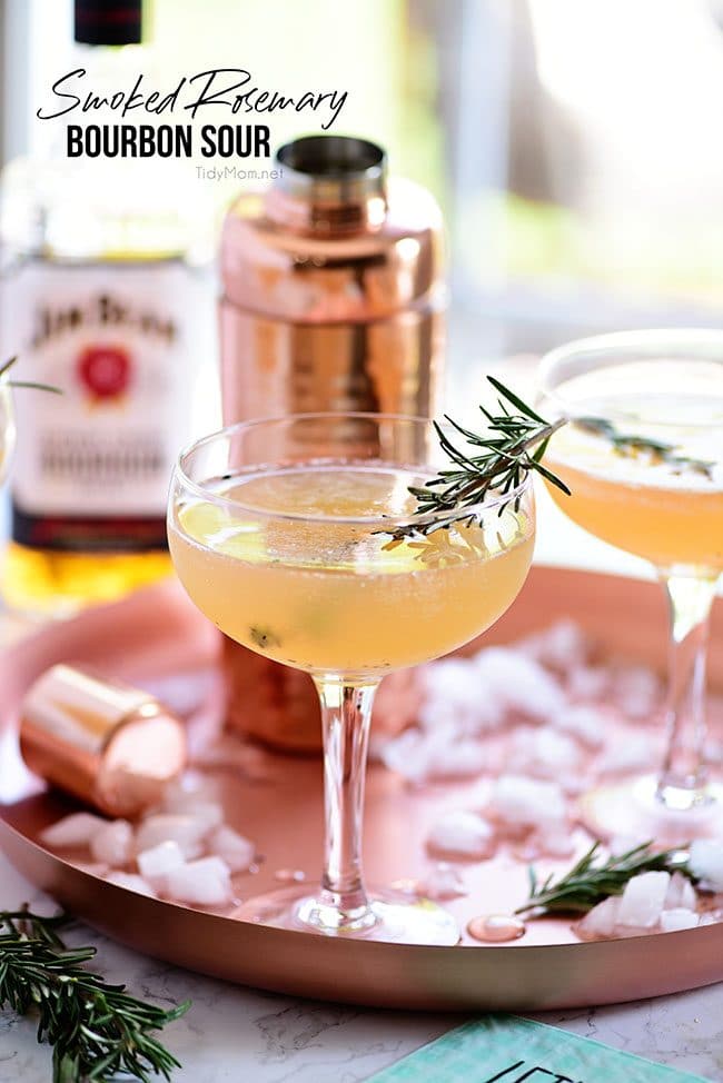  Bourbon Sour with smoked rosemary in coupe glasses