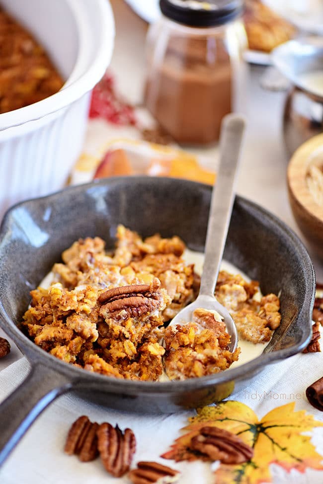 baked pumpkin oatmeal in a bowl with a spoon in a small skillet