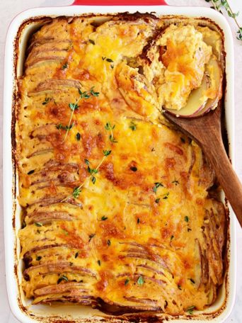 Potatoes au gratin in a red casserole dish