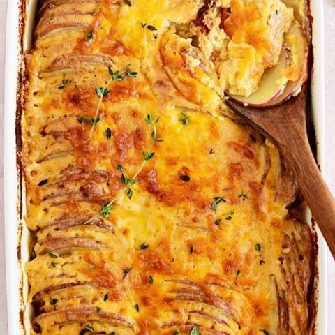 Potatoes au gratin in a red casserole dish