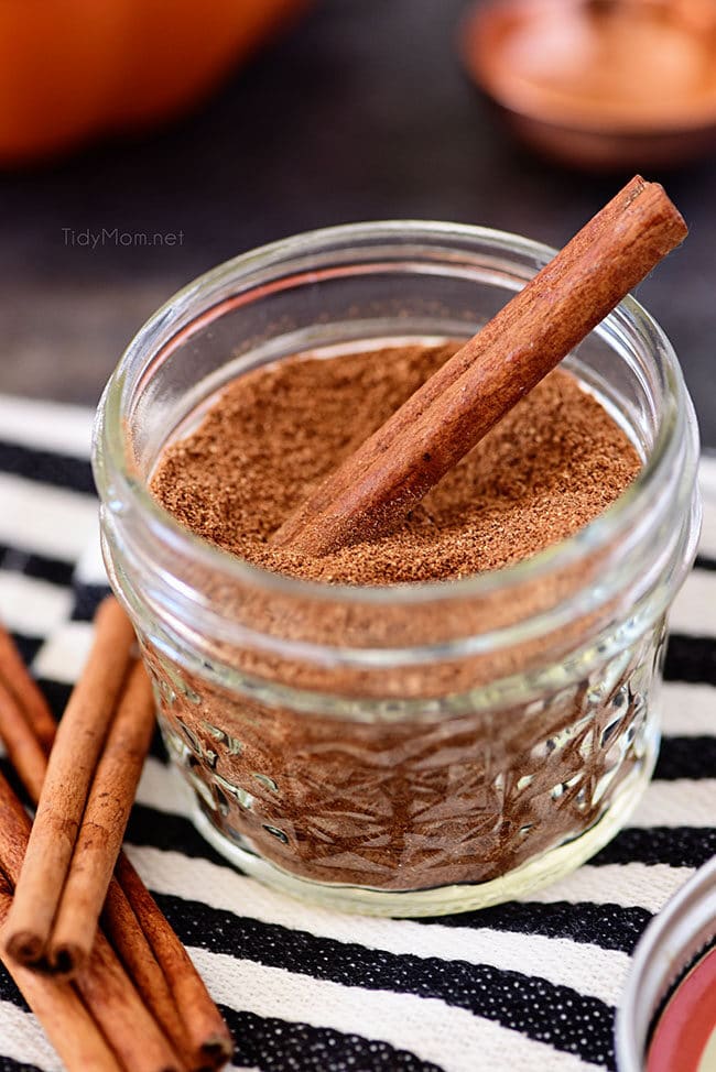 homemade pumpkin pie spice in a jar with a cinnamon stick