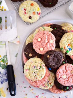chocolate, vanilla and strawberry cookies stacked on plate