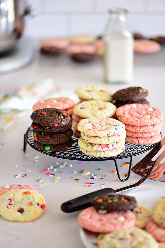 chocolate, vanilla and strawberry cookies stacked on a cooling rack