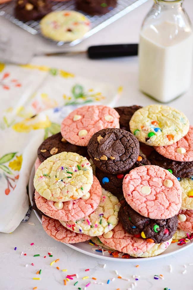 chocolate, vanilla and strawberry cookies stacked on a round cooling rack