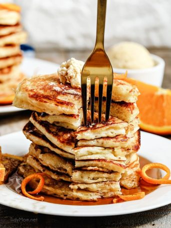 a fork digging into a stack of pancakes