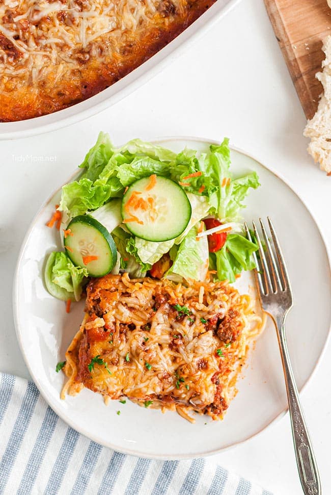 baked spaghetti on a plate with salad