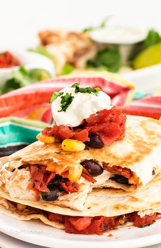 A chicken quesadilla on a plate with sour cream