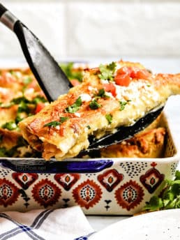 serving enchiladas from a baking dish