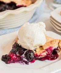 blueberry galette with a scoop of vanilla ice cream on a white plate