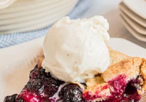 blueberry galette with a scoop of vanilla ice cream on a white plate