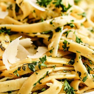 close up of creamy fettuccine alfredo with shaved Parmesan cheese