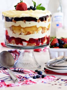 Red white and blue fruit trifle layered dessert in glass bowl