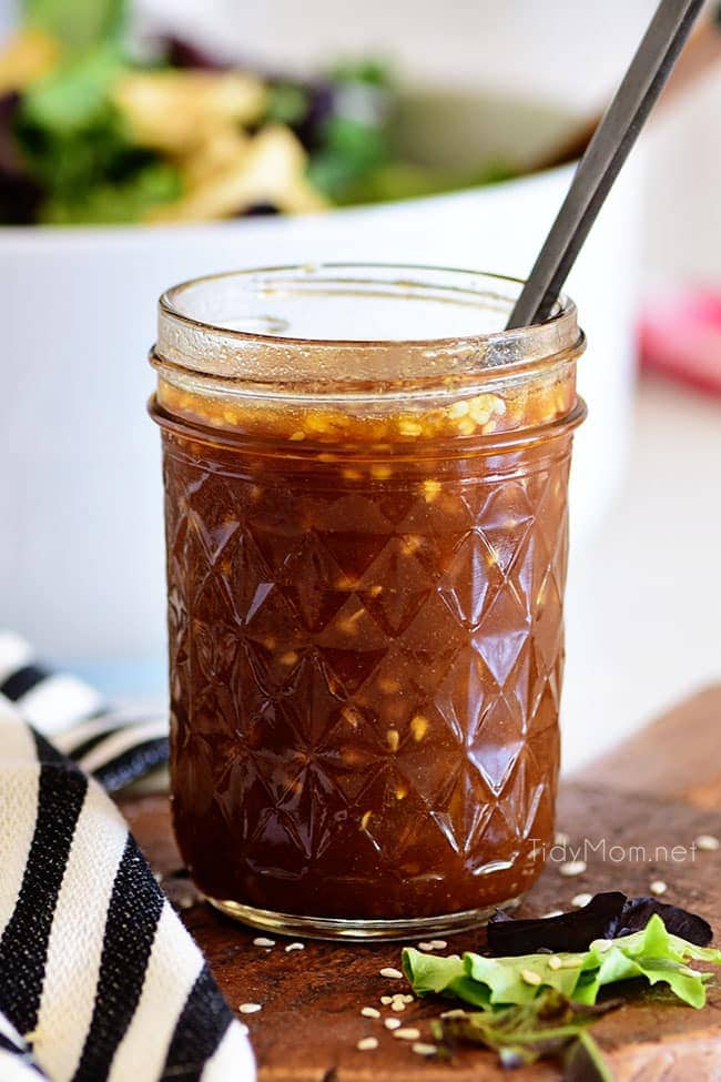 Canning jar with Honey Sesame Asian Salad Dressing and a spoon