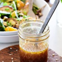 Honey Sesame salad dressing in a jar new to a bowl of salad