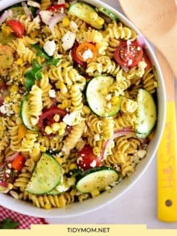 overhead shot of summer pasta salad in a white bowl