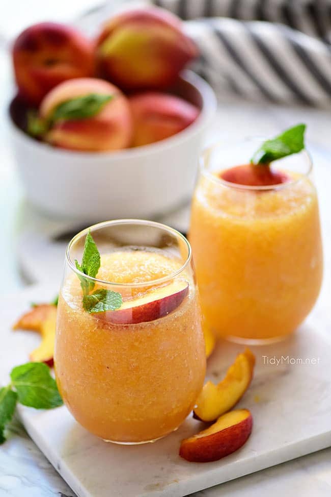 Two frozen peach cocktails in stemless wine glasses