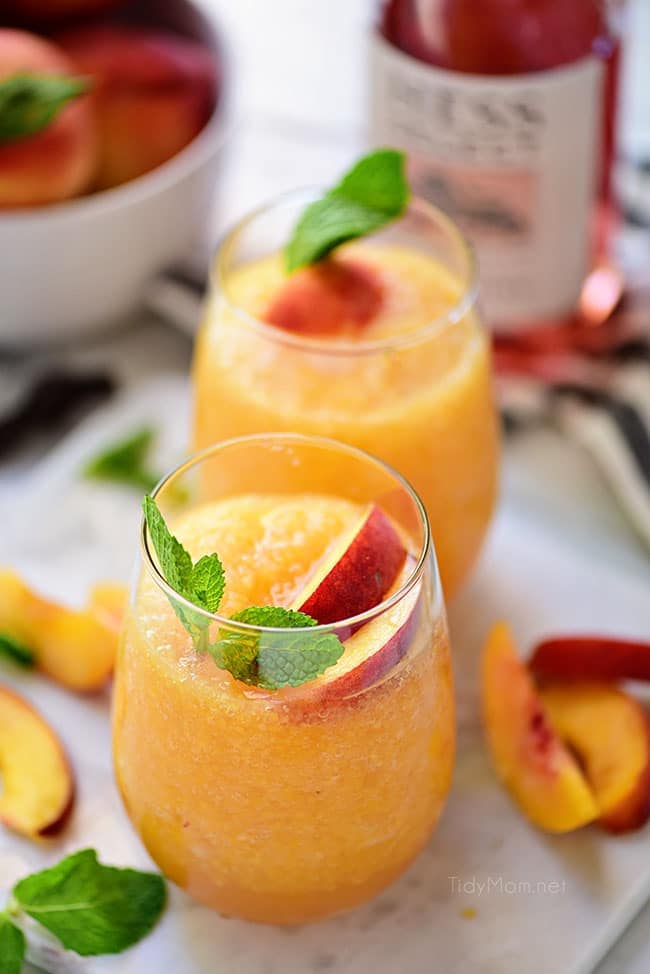 frozen peach slush cocktail with fresh peach garnish