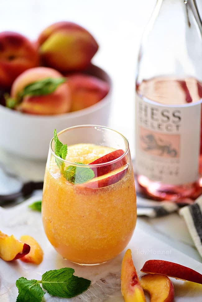frozen peach slush cocktail with a bottle of rose wine