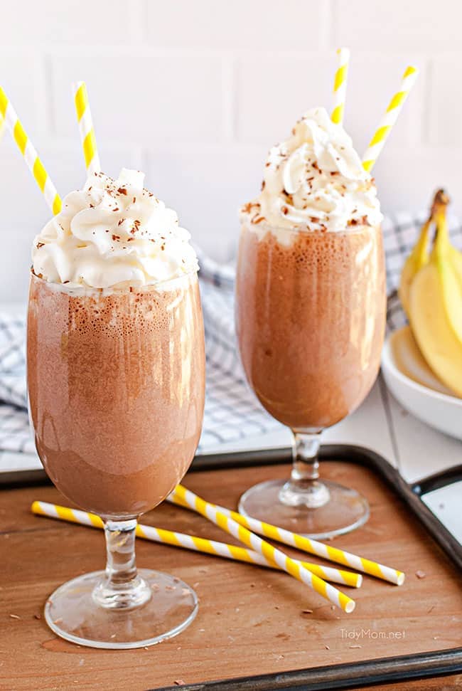 milkshakes with yellow straws on a tray