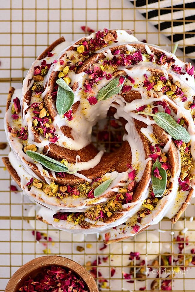 Pistachio Bundt Cake with icing drizzled and garnished with dried rose petals and pistachios
