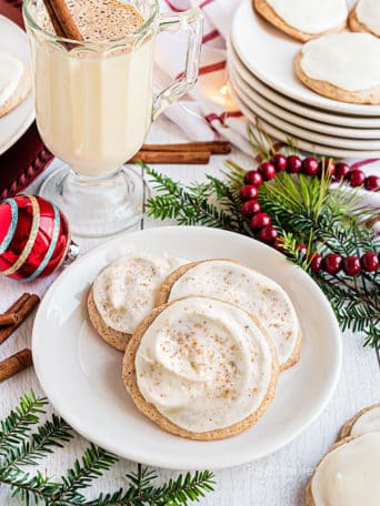 cookies on a plate with a mug of eggnog