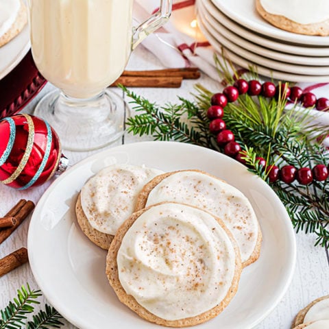 cookies on a plate with a mug of eggnog