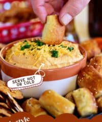 dipping pretzel into a bowl of beer cheese dip