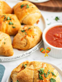 chicken empanadas on white plates on a table with red sauce for dipping