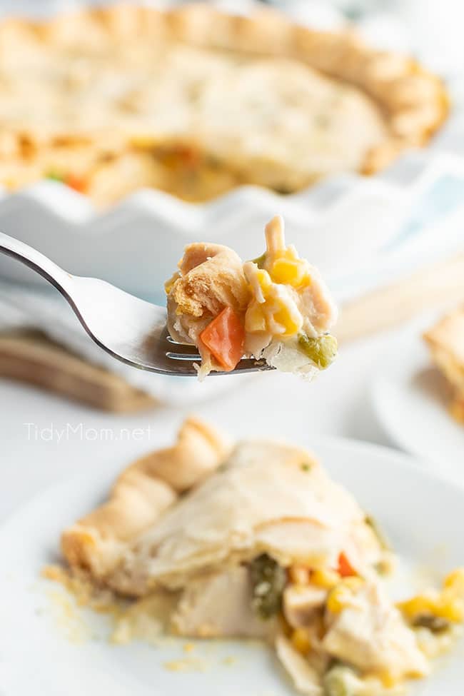bite of chicken pot pie on a fork, with pie in the background