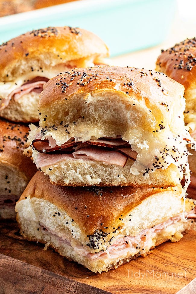 ham sliders stacked and on a wood tray