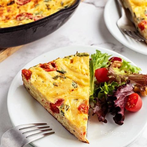 frittata serving on a plate with a salad