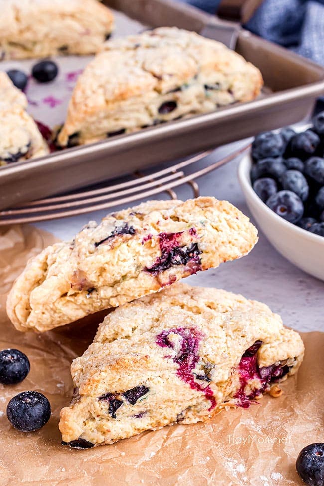 scones on a pan and on a counter with blueberries