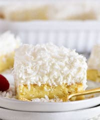 Slice of coconut sheet cake on a white plate