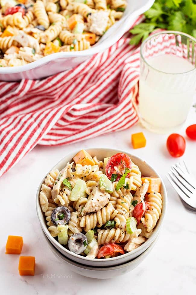 bowl of pasta salad with chicken and a red striped napkin