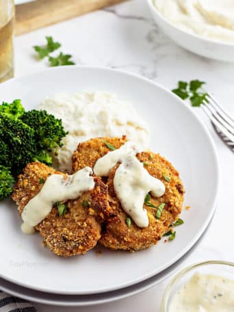 crispy pork medallions with sauce on white plate