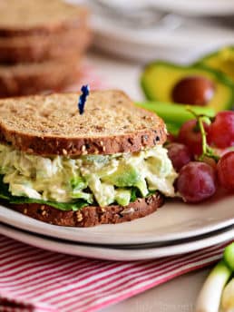 avocado chicken salad sandwich on a plate with grapes