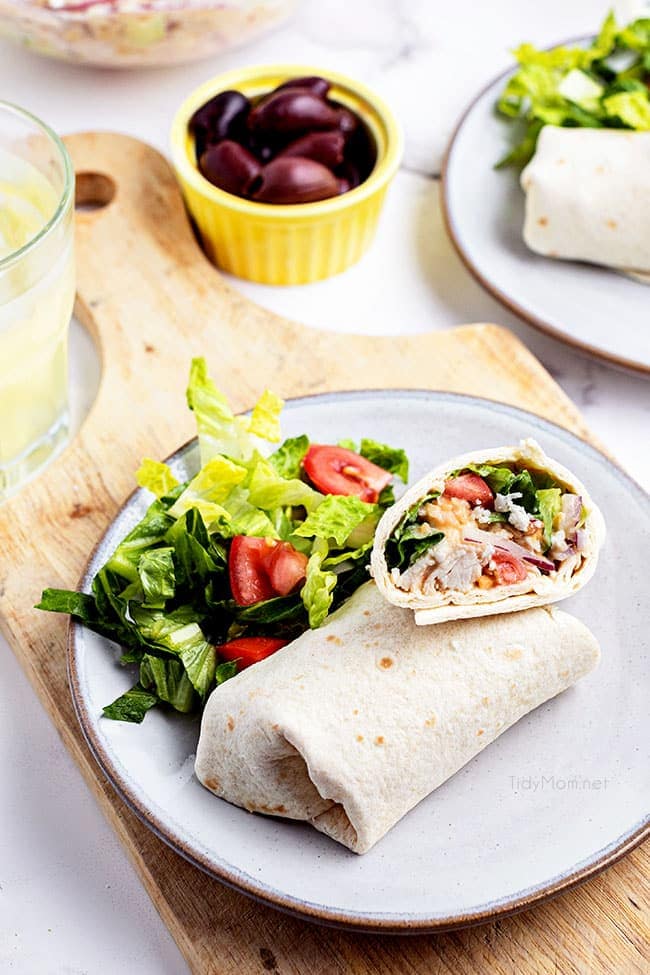 chicken wrap on a plate with a salad 