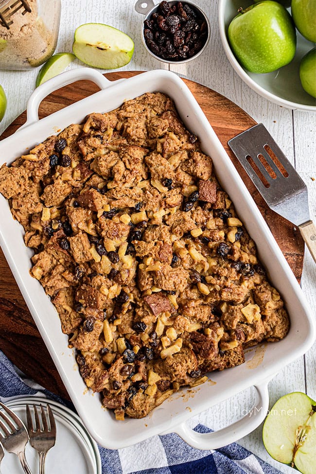 A white baking dish with warm apple bread pudding