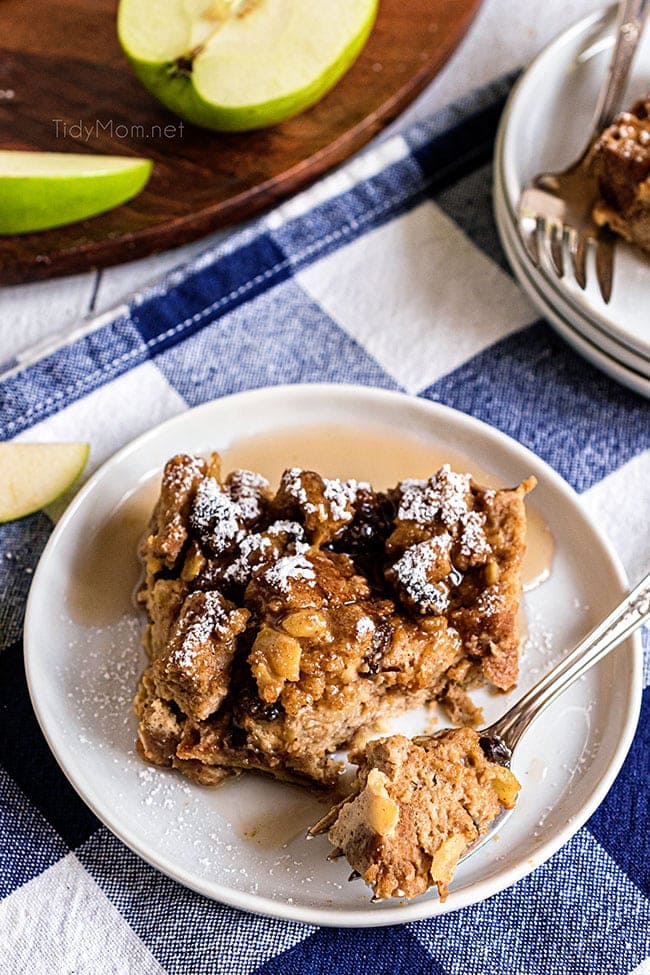 peanut butter apple bread pudding on a white plate with a blue checked napkin 