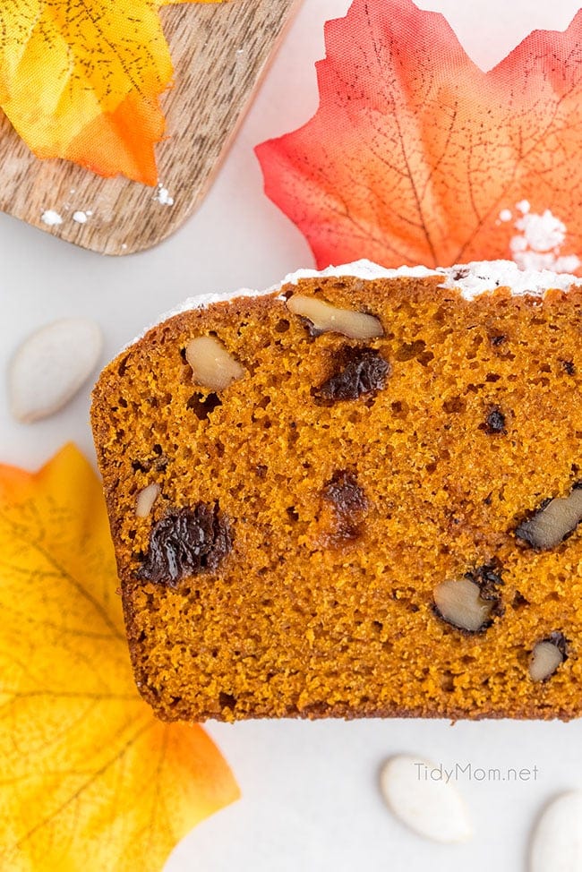 slice of pumpkin bread on a counter with fall leaves