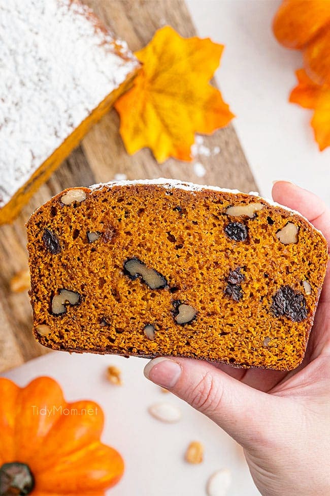 woman's hand holding a piece of pumpkin bread