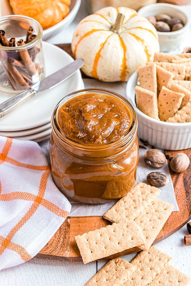 a jar of pumpkin butter with little pumpkins and an orange checked town on the counter