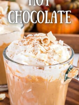 pumpkin spice hot chocolate in a glass mug with whipped cream