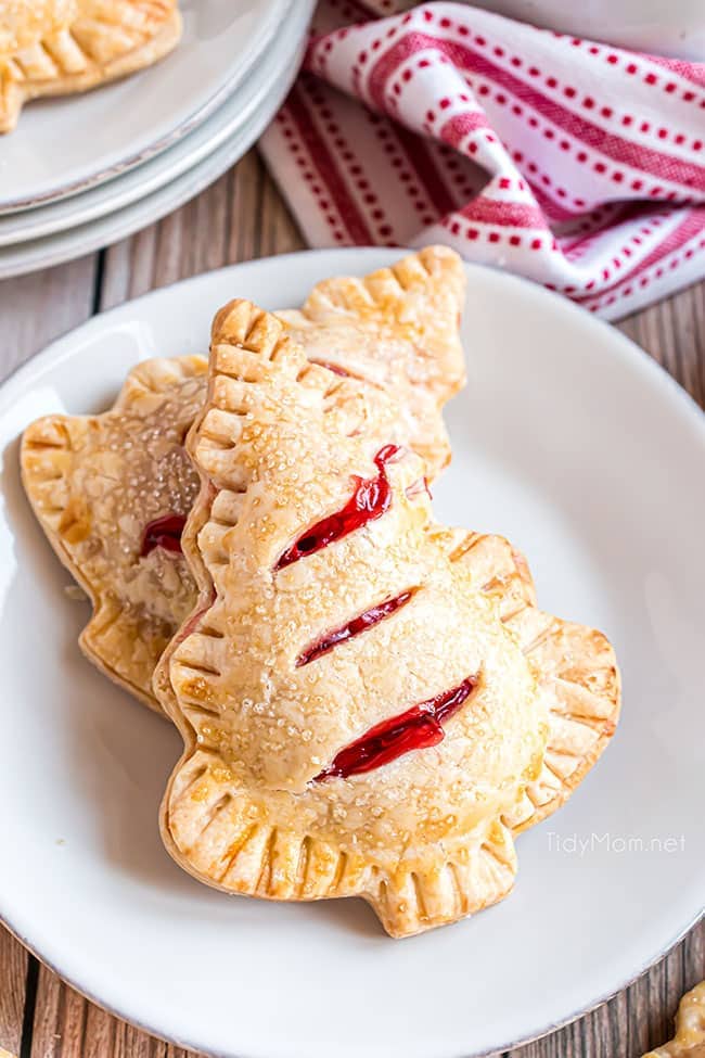 Two Christmas tree handheld cherry pies on a white plate