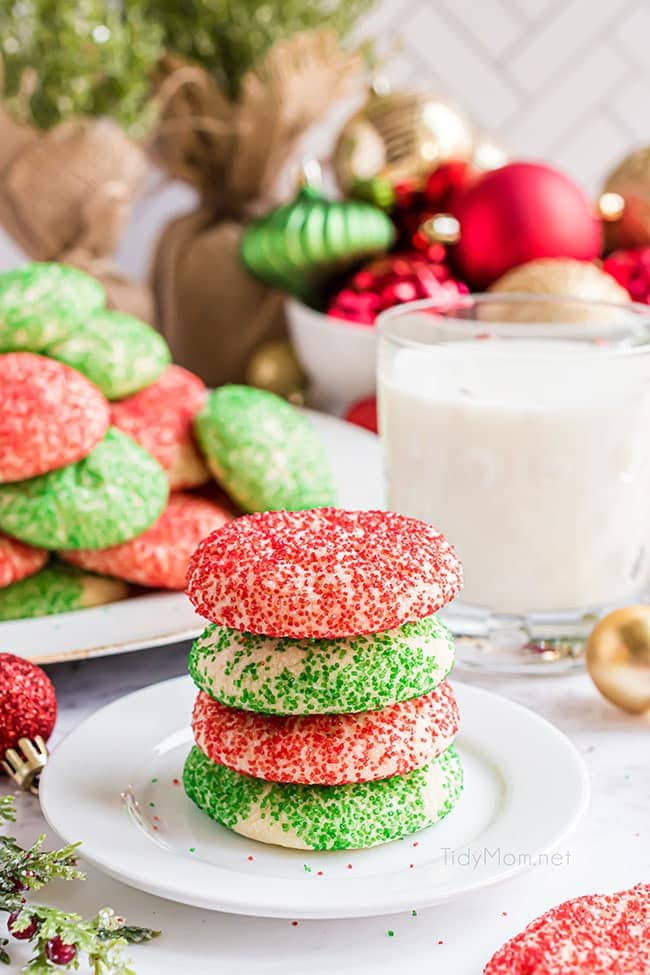 A stack of four Christmas drop sugar cookies on a holiday table
