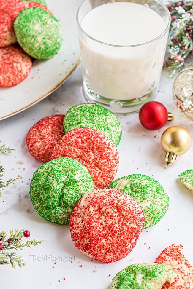 Christmas drop sugar cookies on a counter with a glass of milk