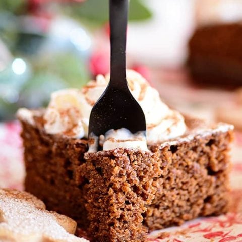a black forking going into a serving of gingerbread cake on a red